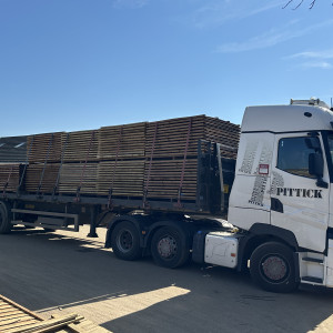 Wholesale fence panels stacked in bulk quantities for merchant delivery.