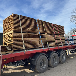 Fencing and timber products loaded onto an articulated lorry for trade supply.